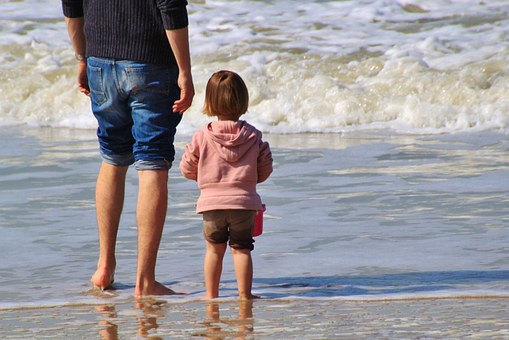 Father and Daughter Looking at the Ocean From the Back