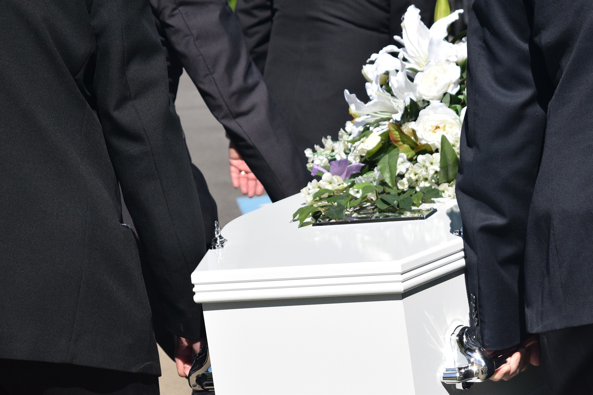 Coffin White Six Men in Black Suits Carrying Flowers on Top