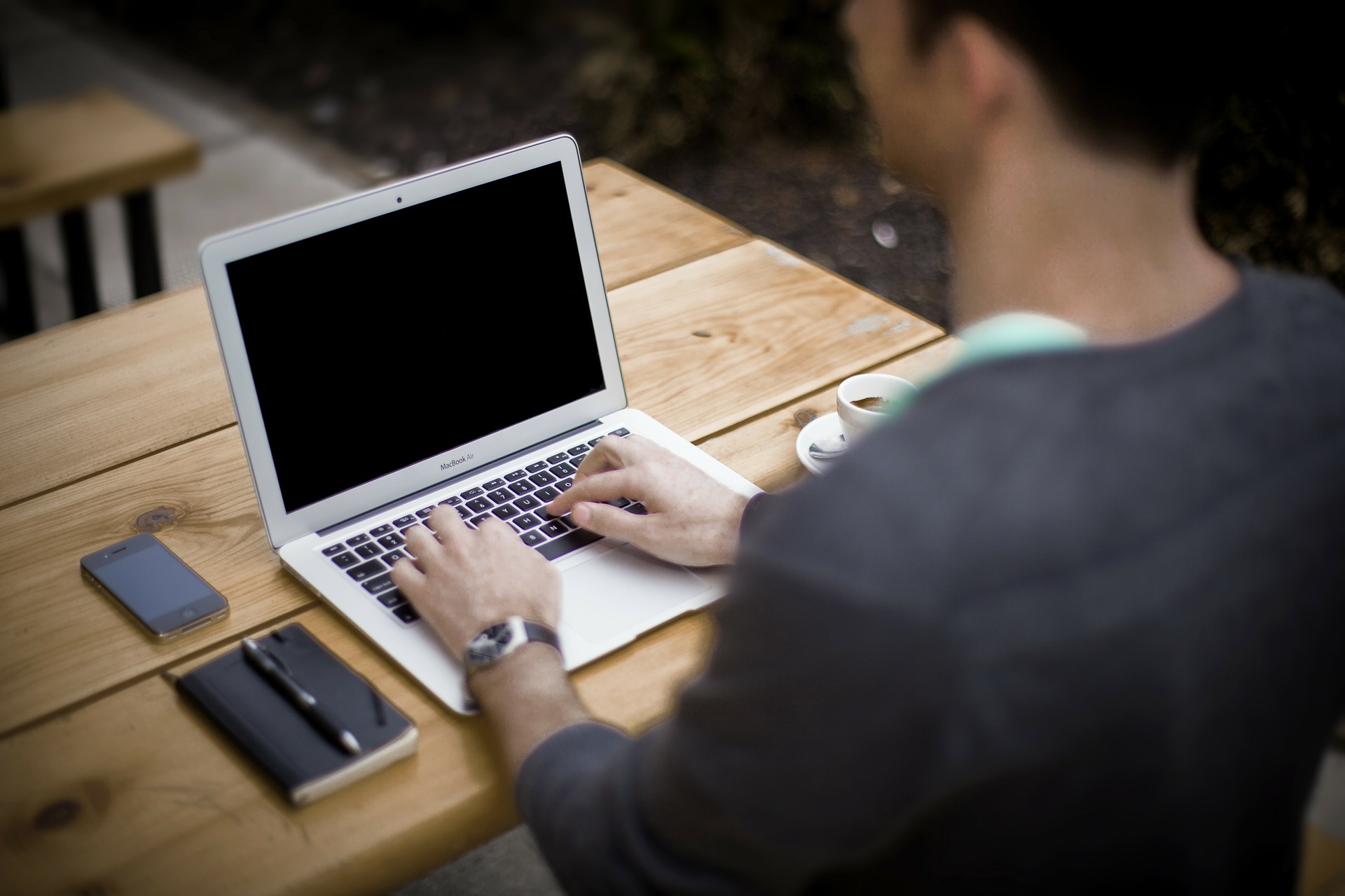 Computer Laptop With Man in Black Shirt at the Keyboard