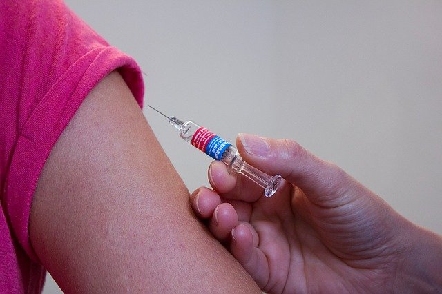 Vaccination-Needle Poised Above Arm Red Shirt
