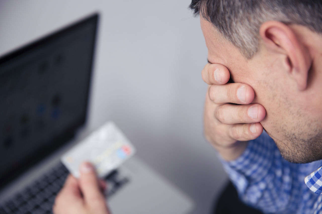 Man Holding Head with Hand and Holding credit card 2