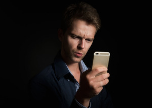Phone man Holds Phone and Looks Angry Brown Background-g96c0c2b3c_640