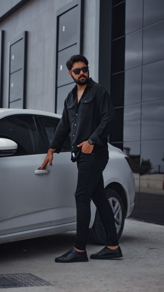stylish bearded man in sunglasses opening modern car
