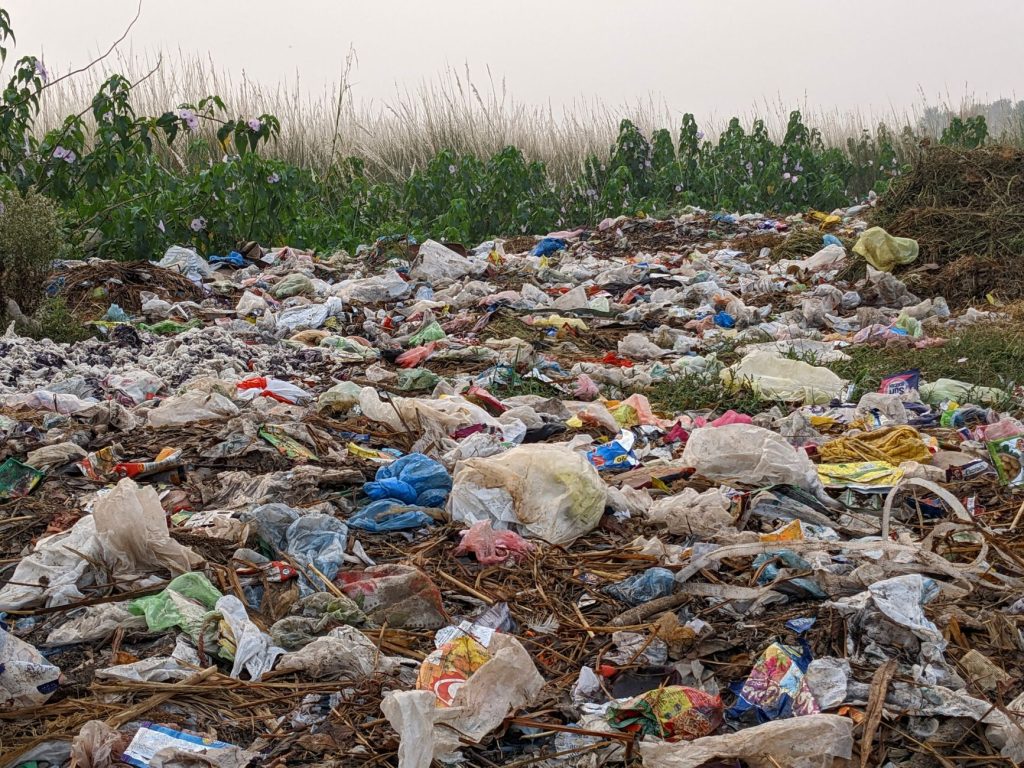 field covered in plastic bags and other trash