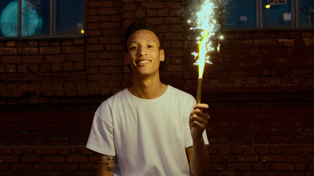 man in white crew neck t shirt holding fire