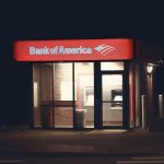 an atm machine on the side of the road during night time