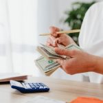woman counting money with calculator
