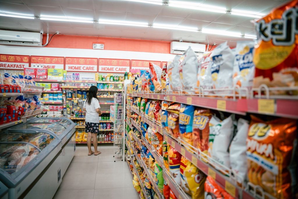 woman standing at end of aisle in supermarket