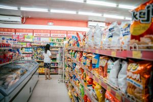 woman standing at end of aisle in supermarket