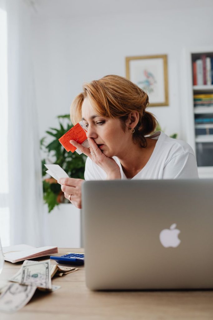 worried woman looking at receipts at the desk