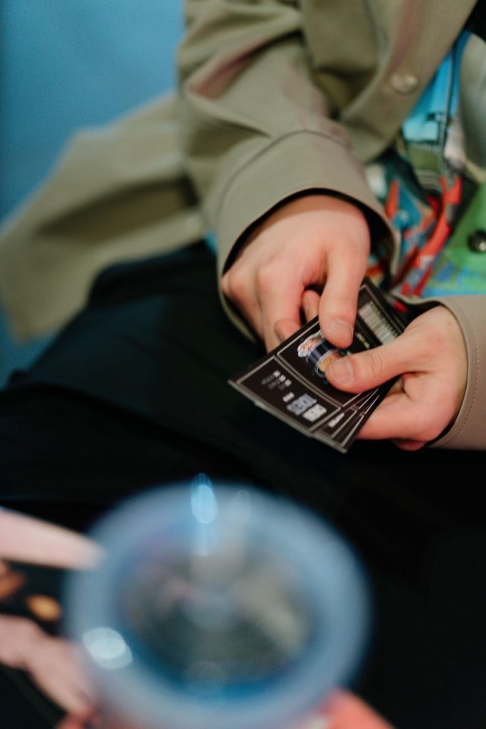 a person in long sleeve shirt holding movie tickets